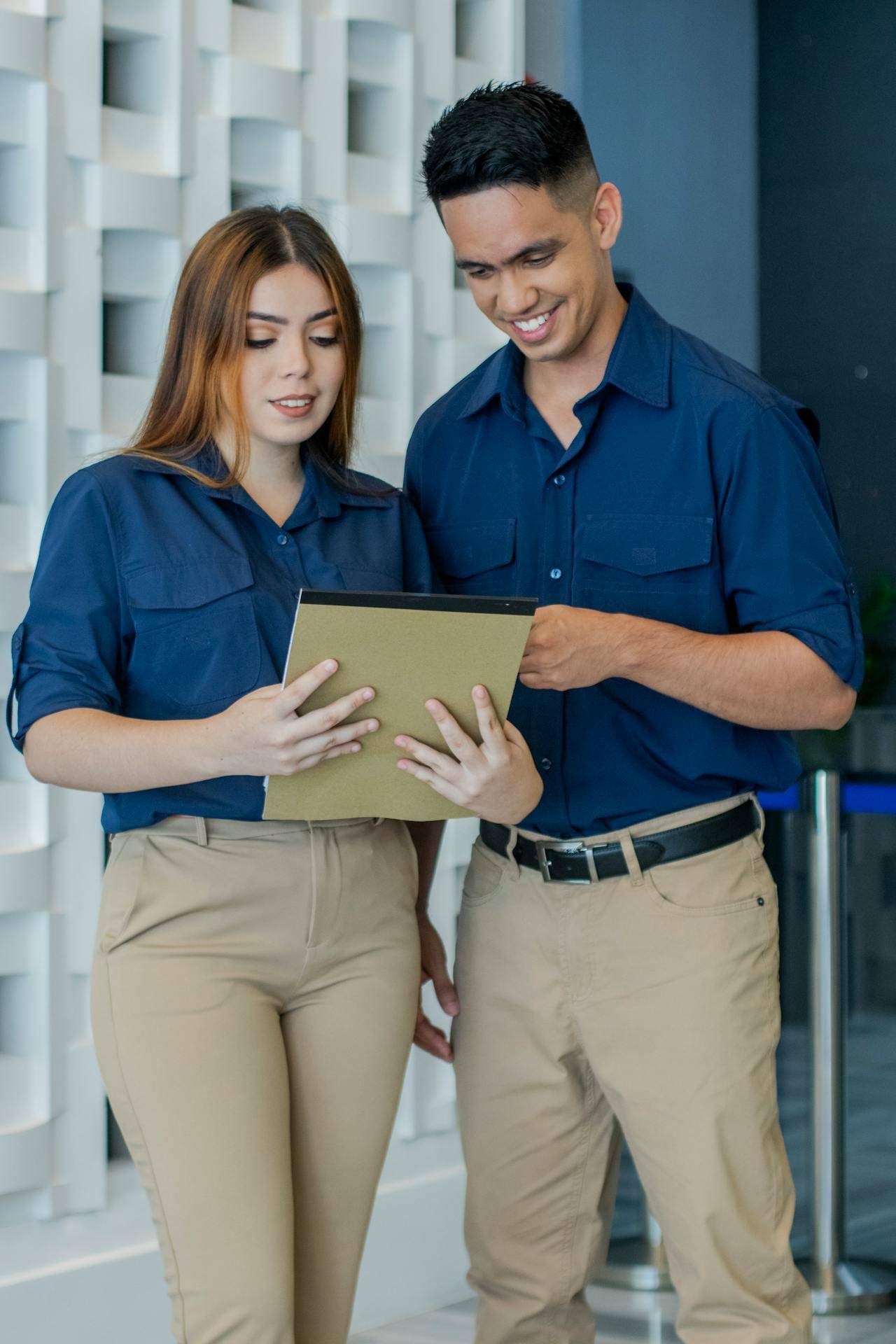 Um casal com roupas sociais setor administrativo segurando uma pasta nas mãos